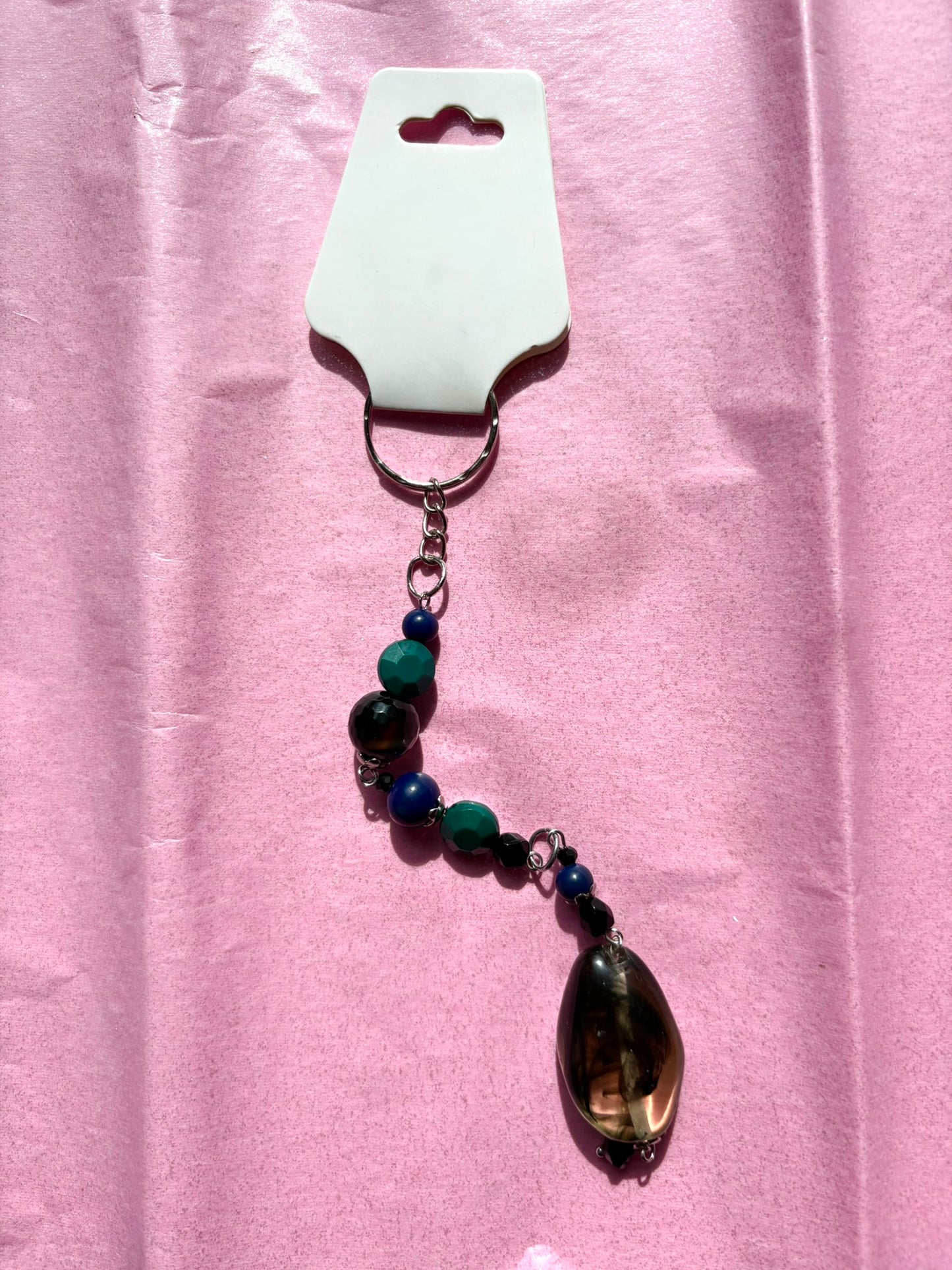 Beaded keychain with a large teardrop-shaped pendant on a pink background