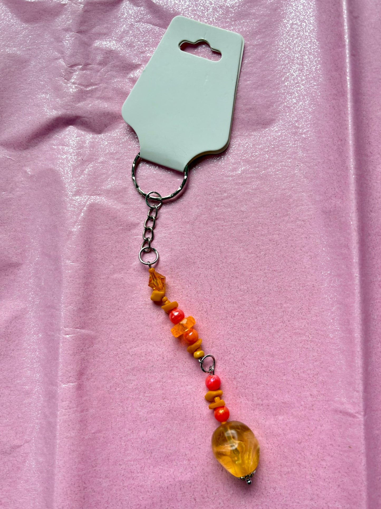 Beaded keychain with a yellow pendant on a pink background