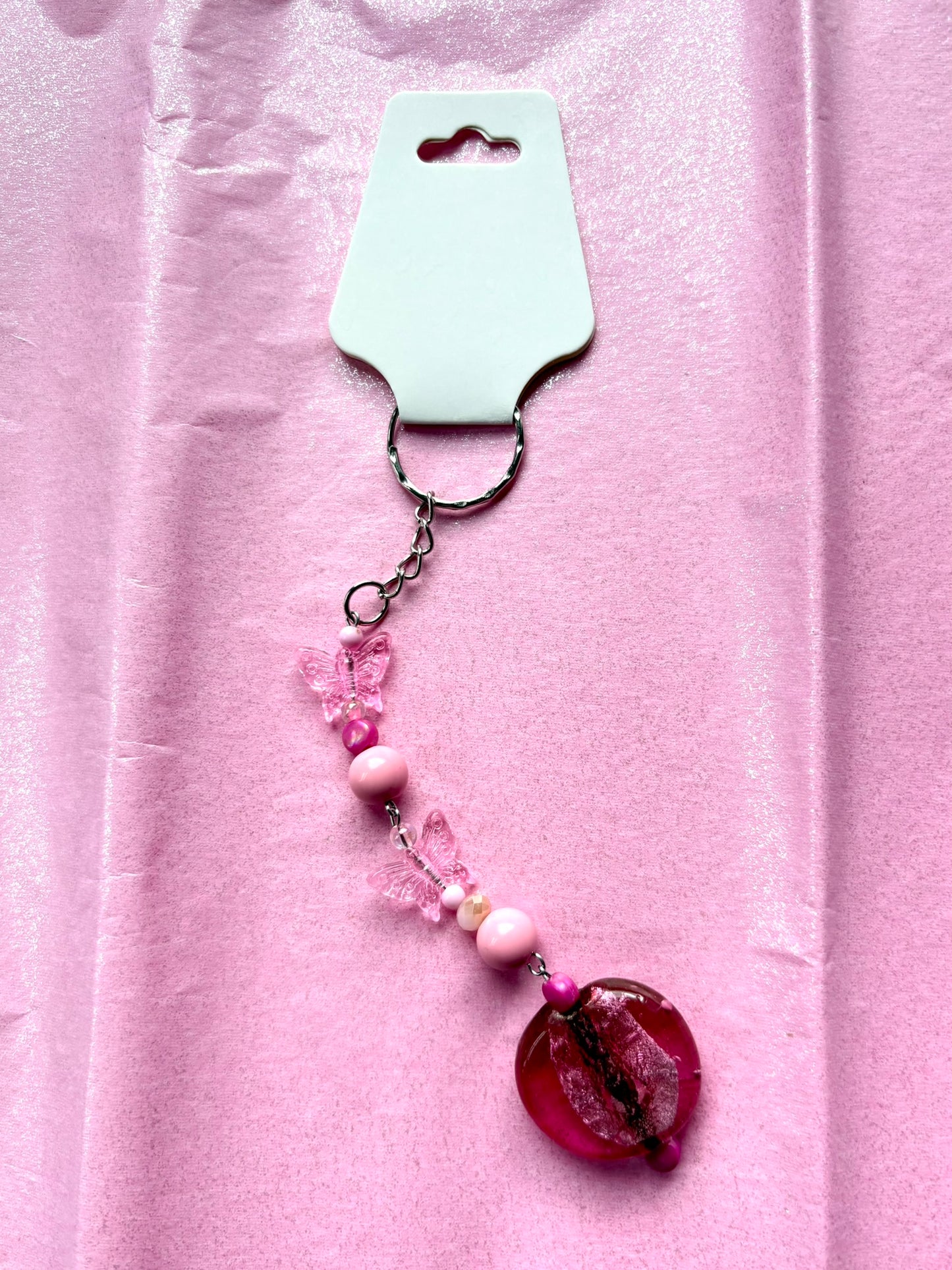 Pink beaded keychain on a pink background