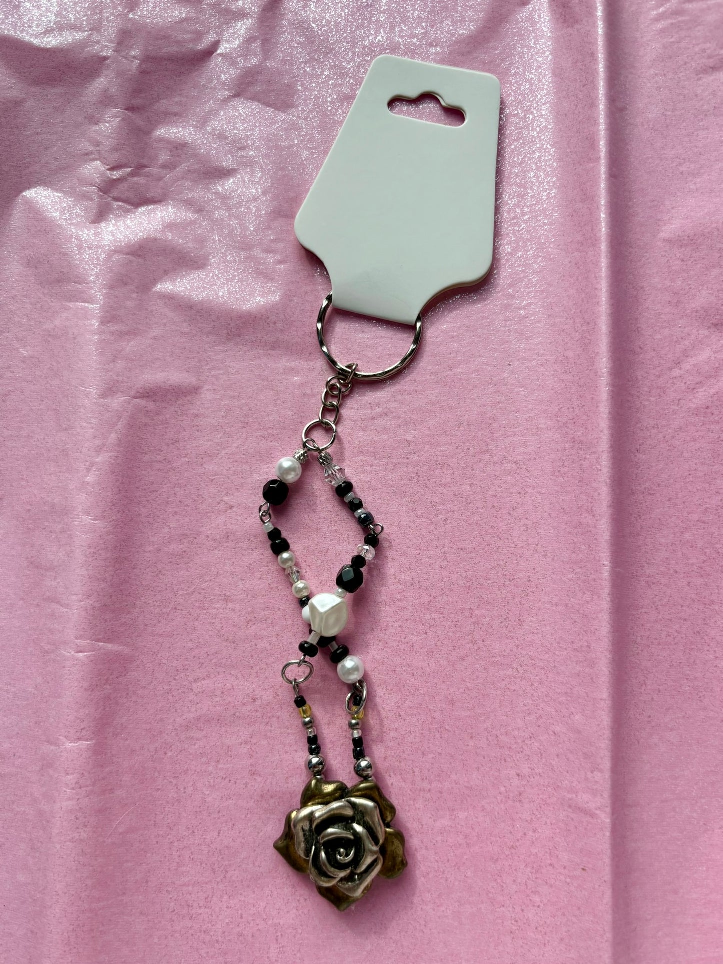 Decorative keychain with rose design on a pink background