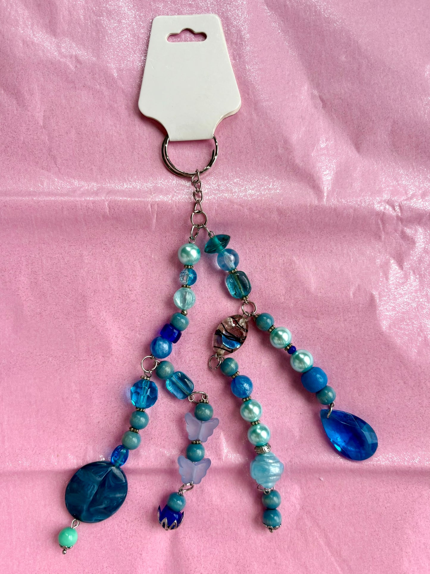 Blue beaded keychain on a pink background