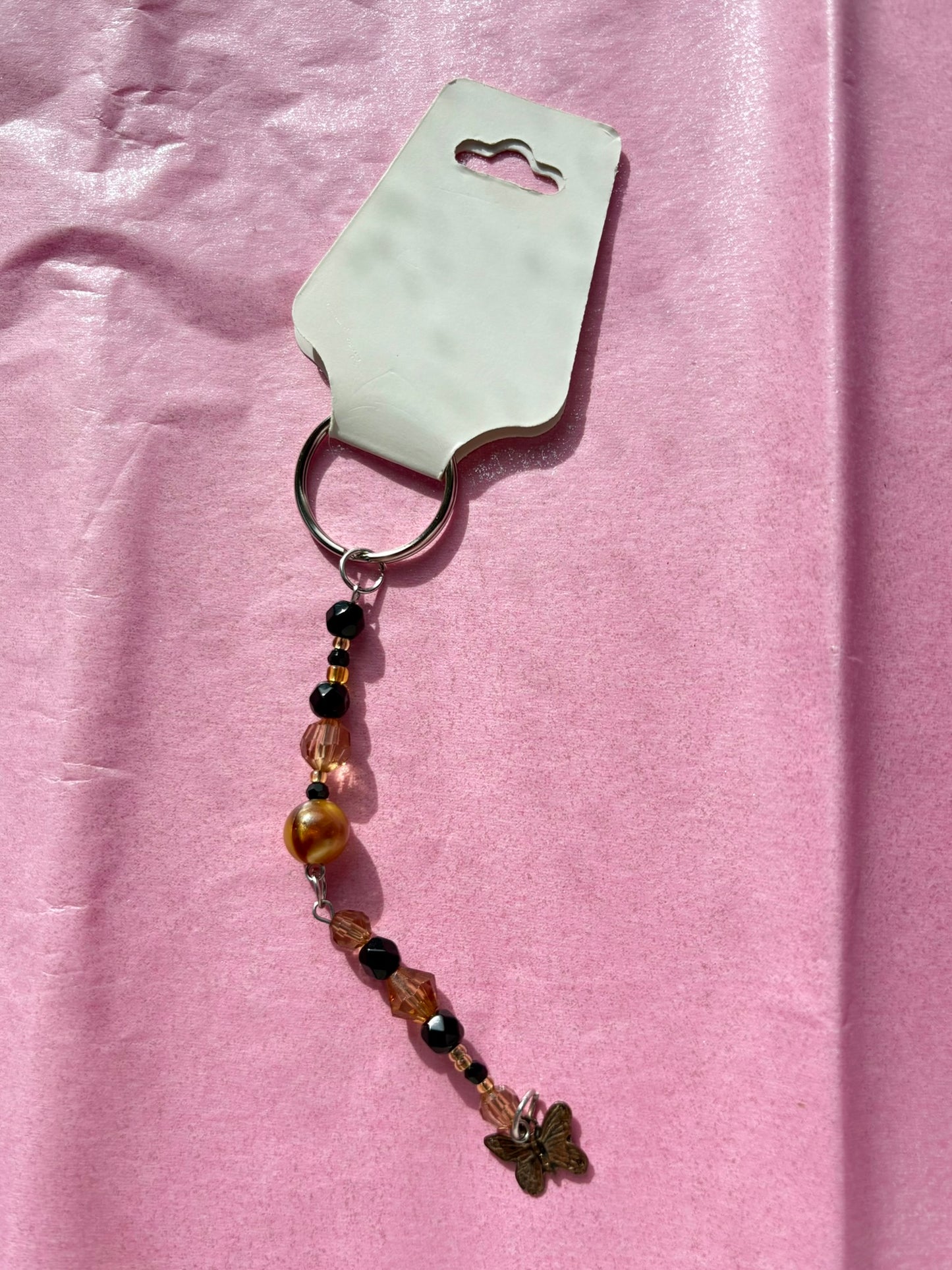 Keychain with beads and charms on a pink background