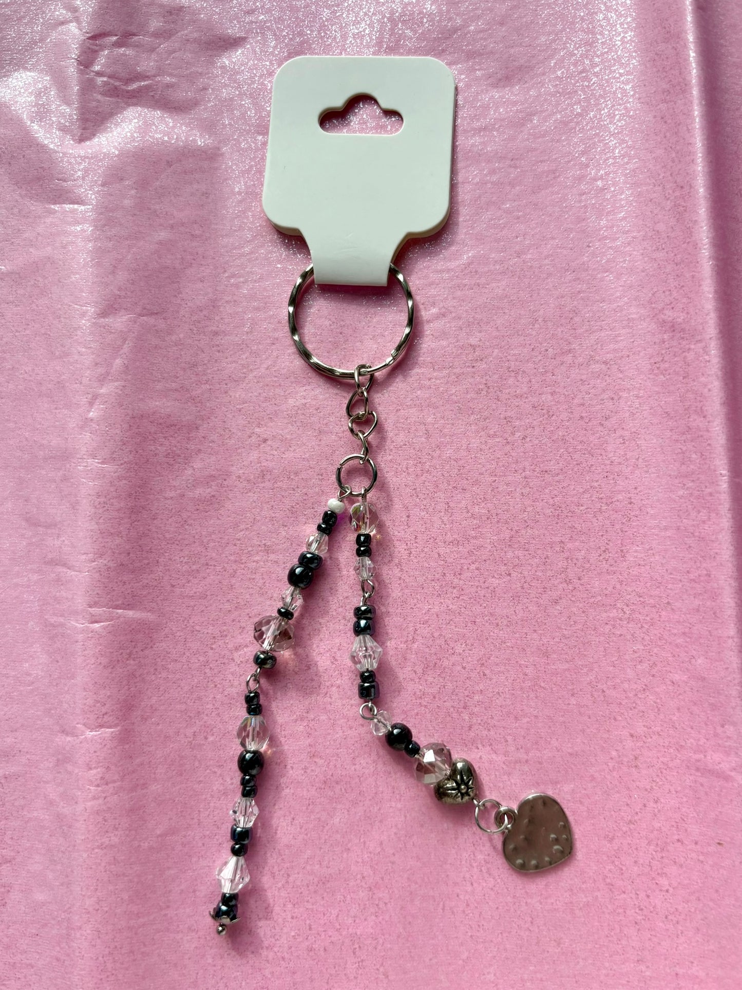 Beaded keychain with heart charm on a pink background