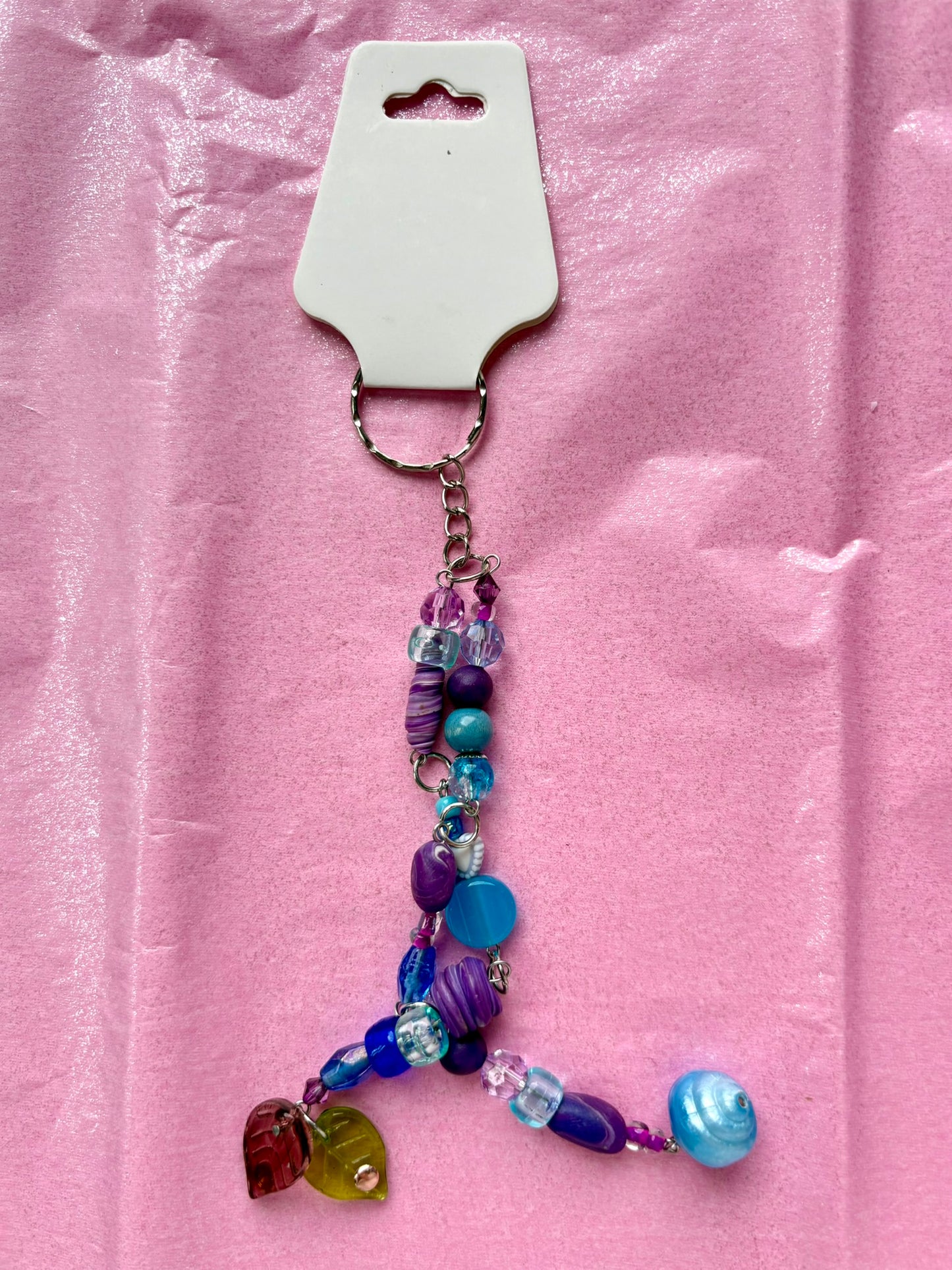 Beaded keychain with colorful beads on a pink background