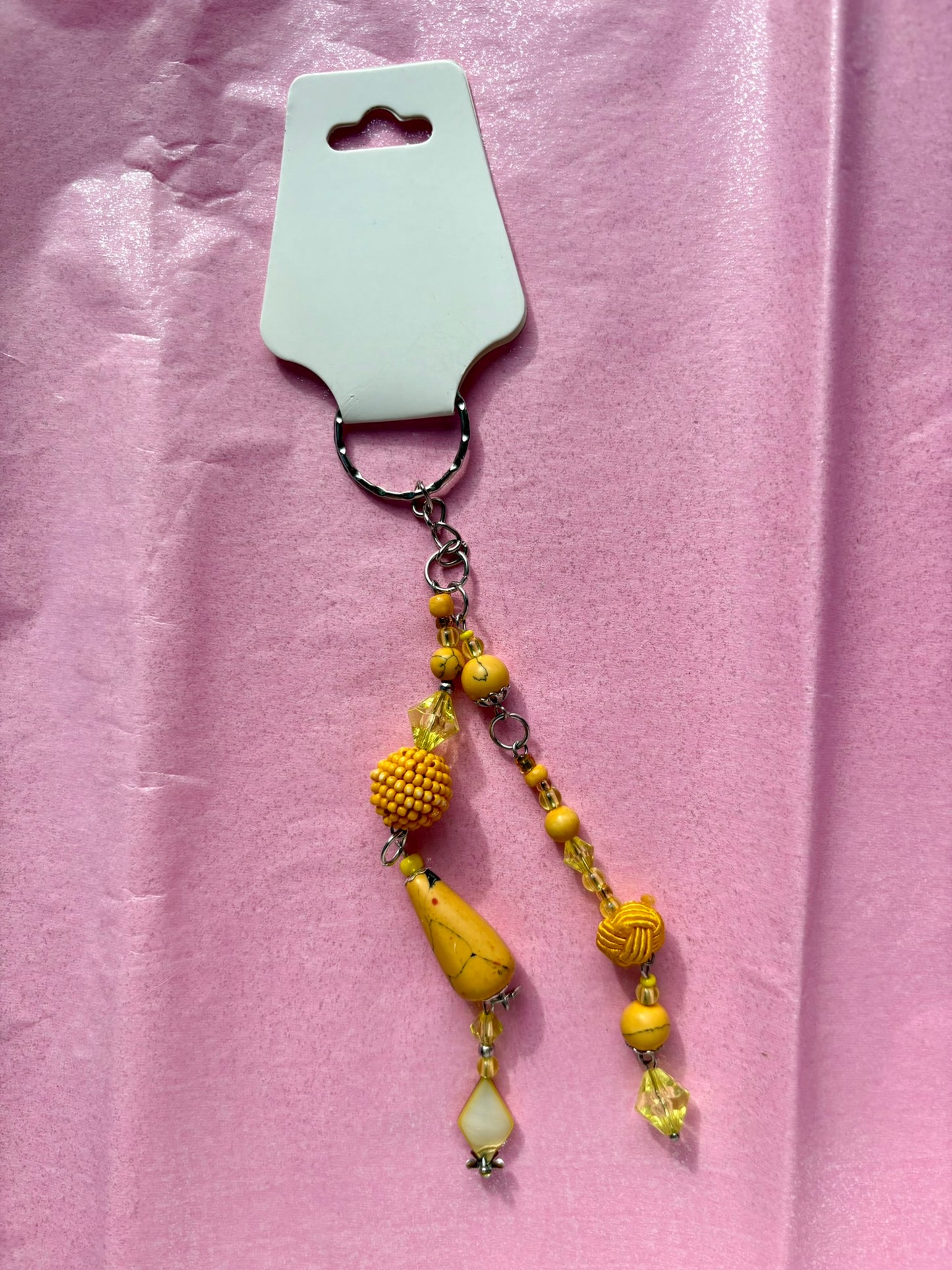 Yellow beaded keychain on a pink background