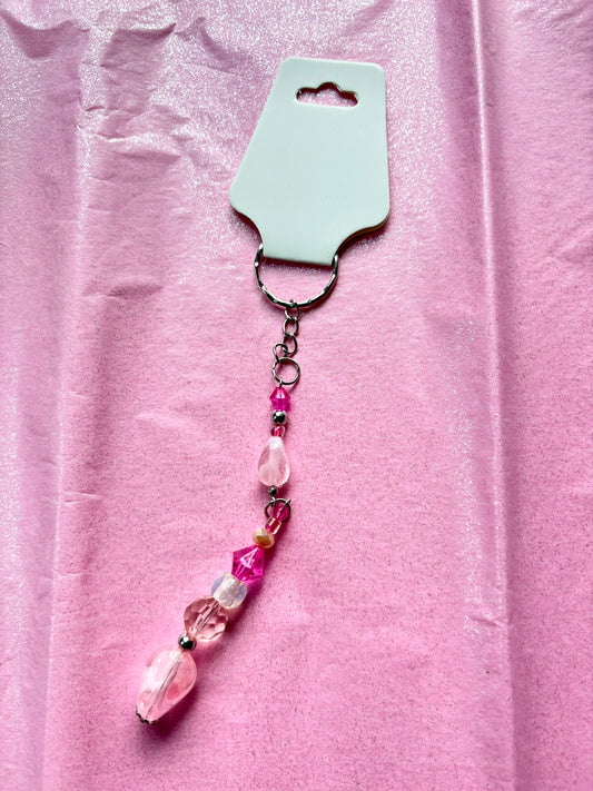 Pink beaded keychain on a pink fabric background