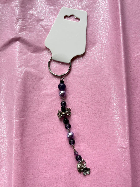 Keychain with beads and charms on a pink background