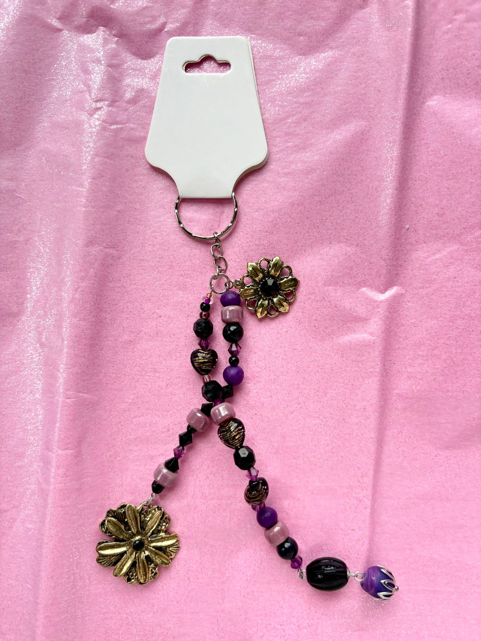 Beaded keychain with floral charms on a pink background
