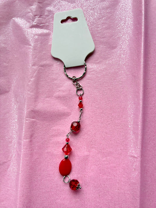 Red beaded keychain on a pink background