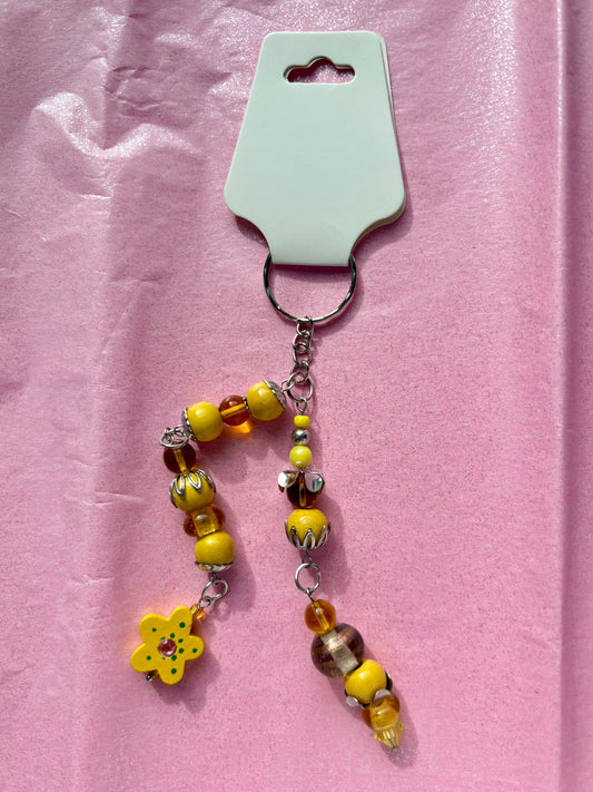 Beaded keychain with a flower charm on a pink background