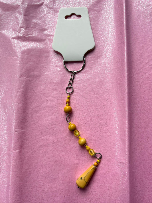 Yellow beaded keychain on a pink background